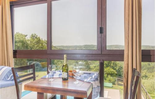 a table with a bottle of wine on it in front of a window at Awesome Home In Meloni With Sauna in Karojba