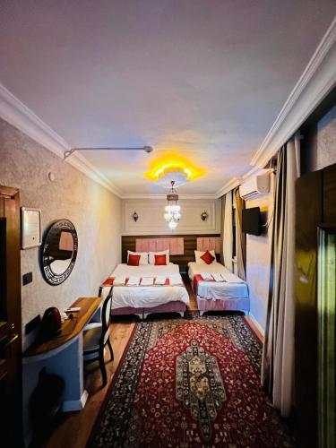 a hotel room with two beds and a table and a desk at Pembe Köşk Old City Center in Istanbul