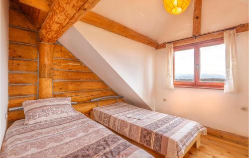 two beds in a attic room with a window at Beautiful Home In Sveti Rok in Sveti Rok