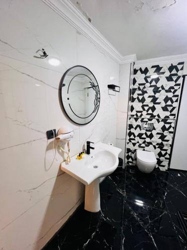 a white bathroom with a sink and a mirror at Pembe Köşk Old City Center in Istanbul