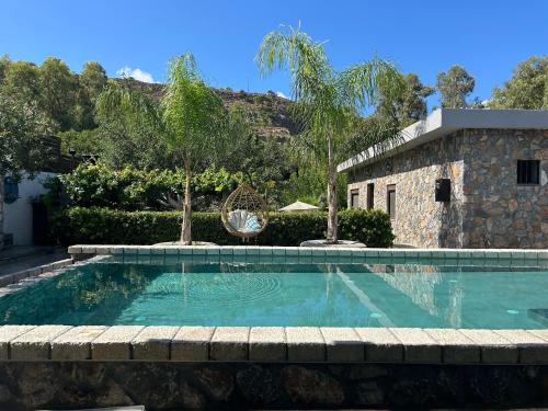 a swimming pool in front of a house at Aithonas Villa in Archangelos
