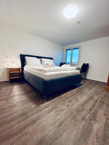 a bedroom with a large bed and a wooden floor at Private room with Bathroom and Lake View in Guest House in Heiden