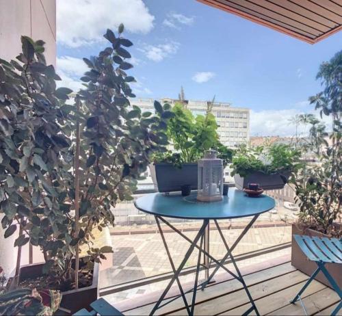d'une terrasse avec une table et des plantes sur un balcon. dans l'établissement L'écrin Urbain, à Strasbourg