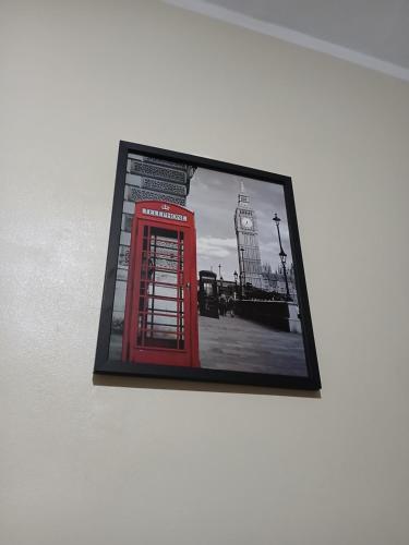 a picture of a red phone booth on a wall at Quarto Privado Cama Casal e Individuais Apto in Rio de Janeiro