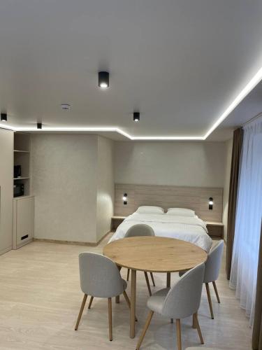 a bedroom with a bed and a table and chairs at Млин готель-ресторан-спа in Tyapche