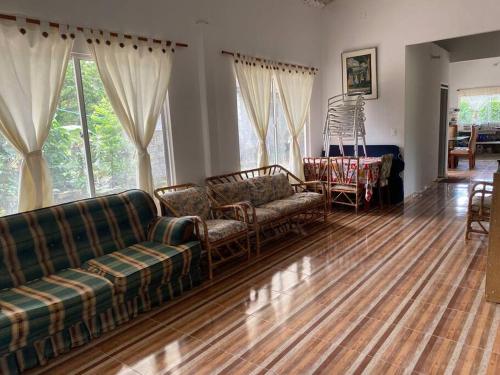 a living room with couches and a wooden floor at Finca Villa Rosita Guamal - Meta in Guamal