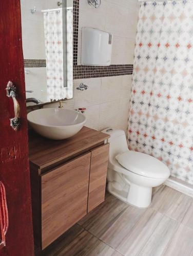 a bathroom with a sink and a toilet and a mirror at Casa colonial - San Antonio Cali in Cali