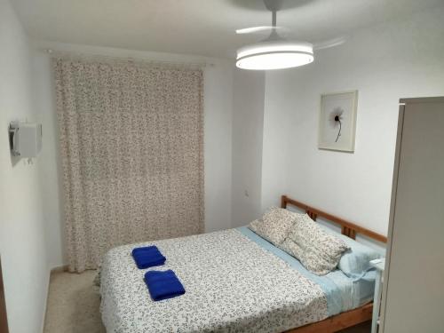 une chambre avec un lit avec des oreillers bleus dessus dans l'établissement Vivienda cercana a la playa con todas las comodidades, à Tarifa