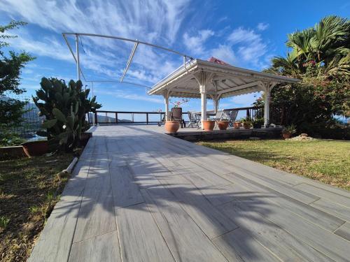 a wooden walkway with a gazebo on the beach at Villa vue panoramique sur La Réserve Cousteau in Bouillante
