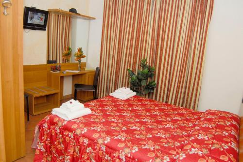 a hotel room with a red bed and a desk at Hotel Chopin in Milan