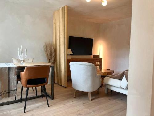 a living room with a table and chairs and a television at A Cozy Home Away from Home in Leatherhead