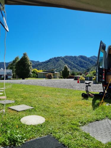 a yard with a table and a chair in the grass at Murchison Motorhome Park in Murchison
