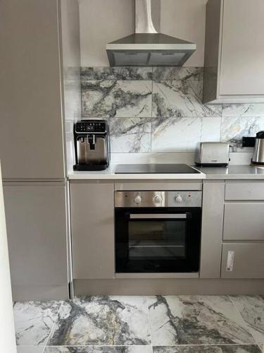 a kitchen with a stove and a counter top at A Cozy Home Away from Home in Leatherhead