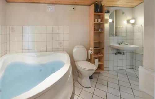 a bathroom with a tub and a toilet and a sink at Holiday Home Hurup Thy With Hot Tub I in Sønder Ydby