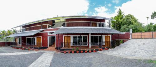 a red brick building with a fence around it at Cozy Haven Homestay in Meenangadi