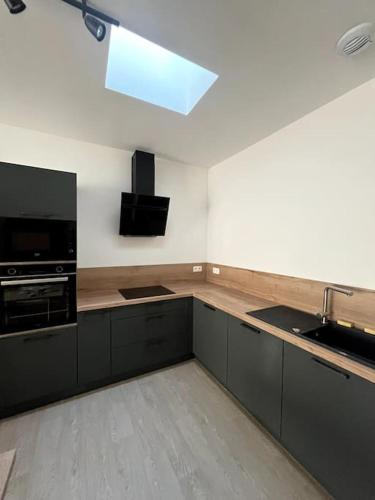 Il comprend une cuisine équipée d'une cuisinière et d'un évier. dans l'établissement Le spacieux et sa terrasse, à Vichy