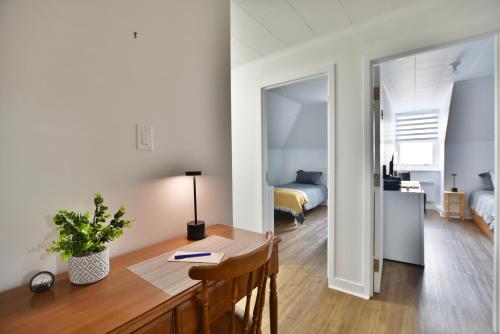 a room with a desk and a bedroom with a bed at Chambre 301 de l'hôtel Victoria confortable et moderne in Saint-Pascal