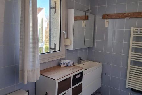 a bathroom with a sink and a mirror at Villa les Oyats- 6 couchages à 200 m de la plage in Wissant