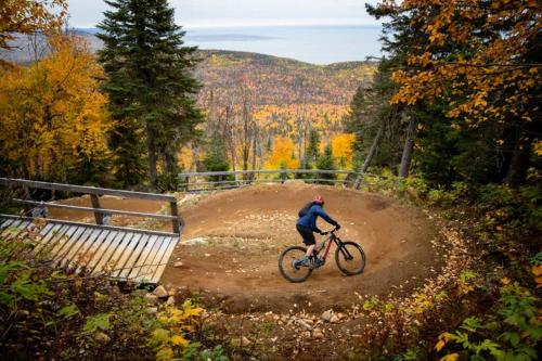 a man riding a bike down a dirt road at Le Boréal - 4CH avec Spa, Wi-Fi et Foyer in Petite-Rivière-Saint-François