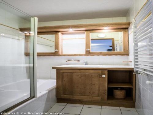 une salle de bain avec un lavabo, une baignoire et un miroir dans l'établissement Chalet De La Place - CHALET DE LA PLACE E8 MAE-4761, à Arc 1800