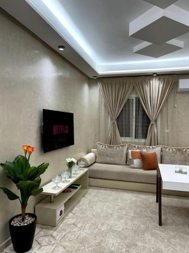 a living room with a couch and a tv at Modern appartement in Agadir in Agadir