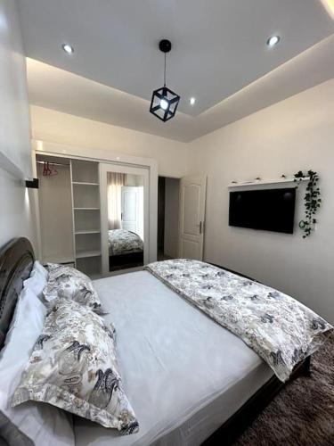 a bedroom with a large bed and a flat screen tv at Modern appartement in Agadir in Agadir