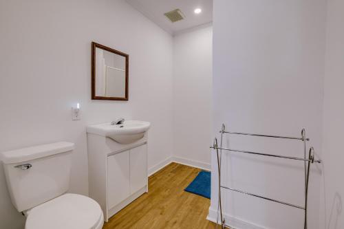 a white bathroom with a toilet and a mirror at Chambre 301 de l'hôtel Victoria confortable et moderne in Saint-Pascal