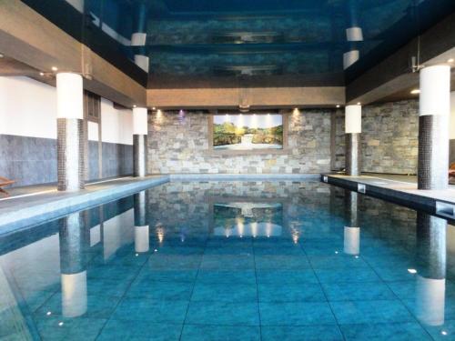 une piscine avec de l'eau bleue dans un immeuble dans l'établissement Résidence Iseran - ISERAN 19 MAE-9961, à Arc 1800