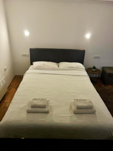 a large white bed with two towels on it at Emily's house in Čelarevo