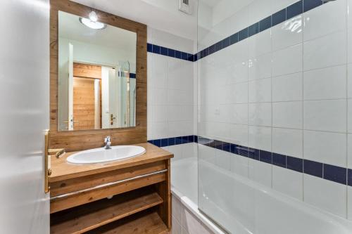 une salle de bain avec un lavabo, une baignoire et un miroir dans l'établissement Résidence Le Parc Des Airelles - Appartement agréable au pied des pistes MAE-5984, aux Orres