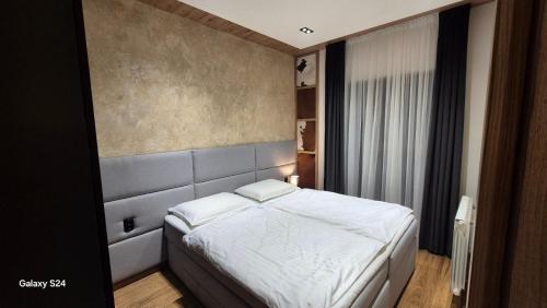 a bedroom with a white bed and a window at Jahorina Apartman Dvosjed B 10 in Jahorina