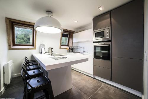 une cuisine avec un grand comptoir blanc et un évier dans l'établissement Résidence Nova - NOVA 5 D3 MAE-0031, à Arc 1800