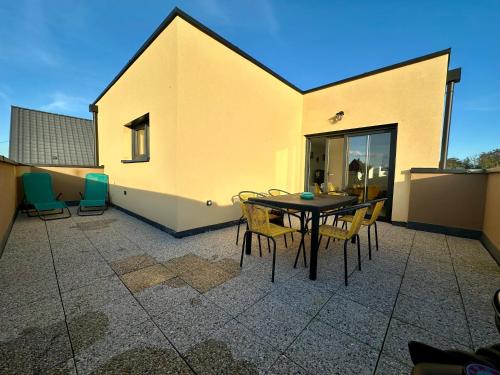a patio with a table and chairs on a building at Europ-Appart --- Europa-Park-Rulantica in Huttenheim