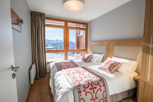 une chambre d'hôtel avec deux lits et une fenêtre dans l'établissement Résidence Les Monarques - MONARQUES 703 MAE-0061, à Arc 1800