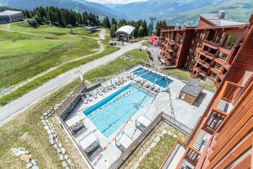 - une vue aérienne sur la piscine d'un hôtel dans l'établissement Résidence Les Monarques - MONARQUES 703 MAE-0061, à Arc 1800