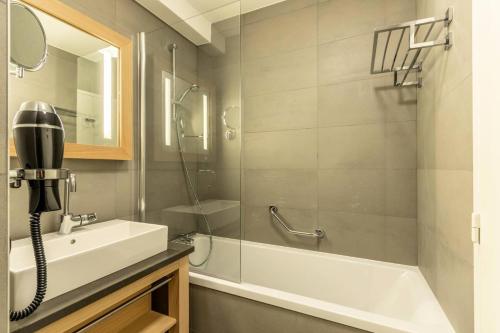 La salle de bains est pourvue d'une douche, d'un lavabo et d'un téléphone. dans l'établissement Résidence Les Monarques - MONARQUES 912 MAE-0141, à Arc 1800