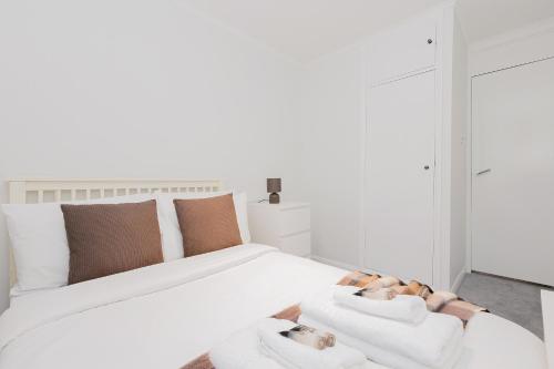 a bedroom with a large white bed with two white towels at 2BR with parking, Mill Hill, NW London, 10min Tube in Mill Hill