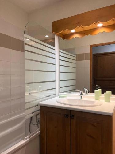 une salle de bain avec un lavabo, une baignoire et un miroir dans l'établissement Résidence Le Grand Panorama - Grand Panorama 214 MAE-7851, à Saint-Gervais-les-Bains