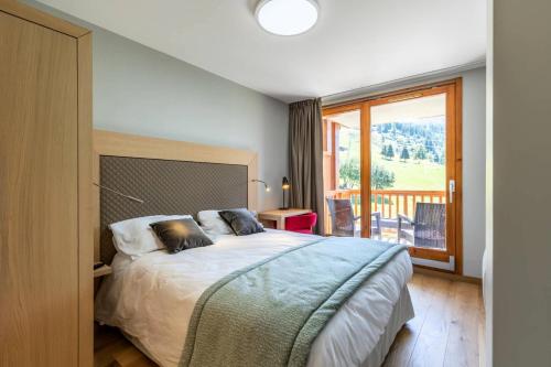 - une chambre avec un lit et un balcon dans l'établissement Résidence Les Monarques - MONARQUES 905 MAE-0151, à Arc 1800