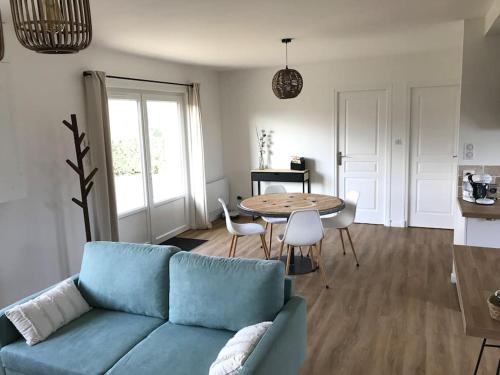 a living room with a blue couch and a table at Tranquillité assurée au Minerai - 85 in Saint-Sulpice-sur-Risle