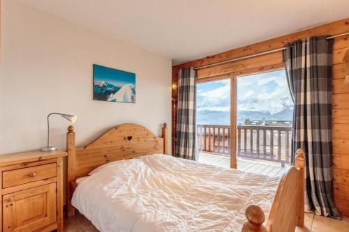 une chambre avec un lit et une grande fenêtre dans l'établissement Résidence Saint Bernard G - ST BERNARD B5-B6 MAE-0231, à Arc 1800