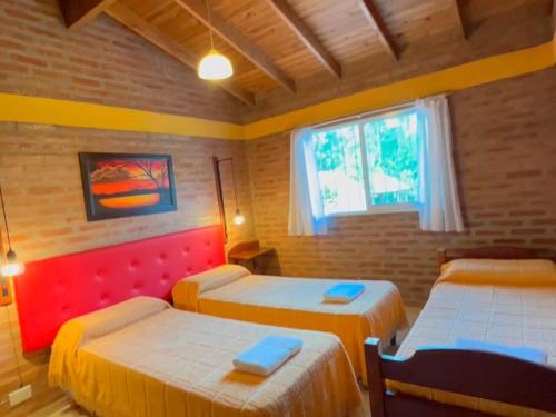 ミナ・クラベロにあるLas Magnolias - Casas de Campoのベッドが3つと窓のある部屋