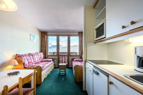 une cuisine et un salon avec un canapé dans l'établissement Résidence Le Sextant - SEXTANT 107 MAE-4781, à La Plagne Tarentaise