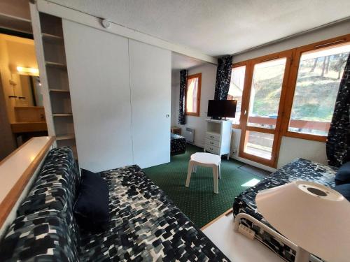 une chambre avec deux lits et une télévision dans l'établissement Résidence Le De 4 - Appartement 2 pièces pour 4 personnes de 25m² MAE-2311, à La Plagne Tarentaise