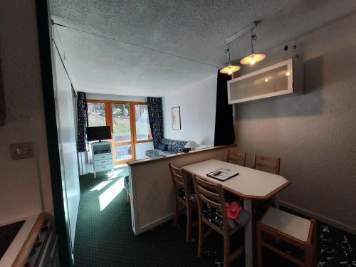 une petite cuisine avec une table et des chaises dans une pièce dans l'établissement Résidence Le De 4 - Appartement 2 pièces pour 4 personnes de 25m² MAE-2311, à La Plagne Tarentaise