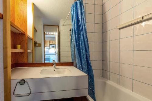 une salle de bain avec un lavabo et un rideau de douche dans l'établissement Résidence Le Zig Zag - ZIG ZAG 39 MAE-0331, à La Plagne Tarentaise