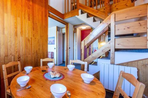 une table en bois dans une chambre avec un escalier en bois dans l'établissement Résidence Le Zig Zag - ZIG ZAG 39 MAE-0331, à La Plagne Tarentaise