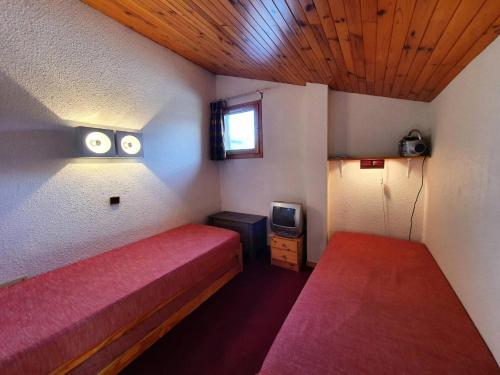 une petite chambre avec un lit et une télévision dans l'établissement Résidence Le Zig Zag - ZIG ZAG 36 MAE-0341, à La Plagne Tarentaise