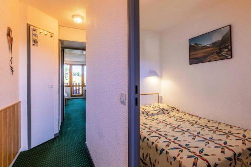 une chambre d'hôtel avec un lit et un couloir dans l'établissement Résidence Le De 4 - Appartement 2 pièces pour 5 personnes de 26m² MAE-0361, à La Plagne Tarentaise