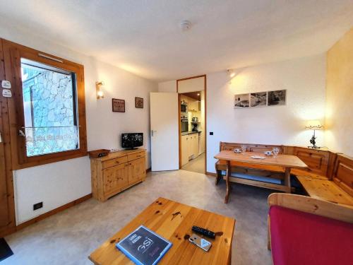 Il comprend un salon avec une table en bois et une cuisine. dans l'établissement Résidence La Boussole - Studio pour 2 personnes de 20m² MAE-0381, à La Plagne Tarentaise